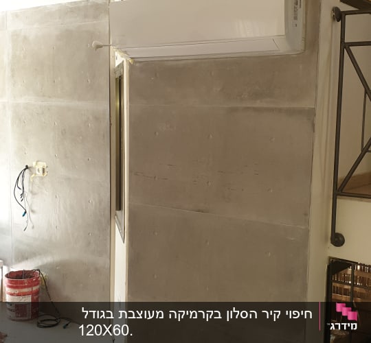 קיר בטון עם מזגן מותקן ודלי צבע על הרצפה